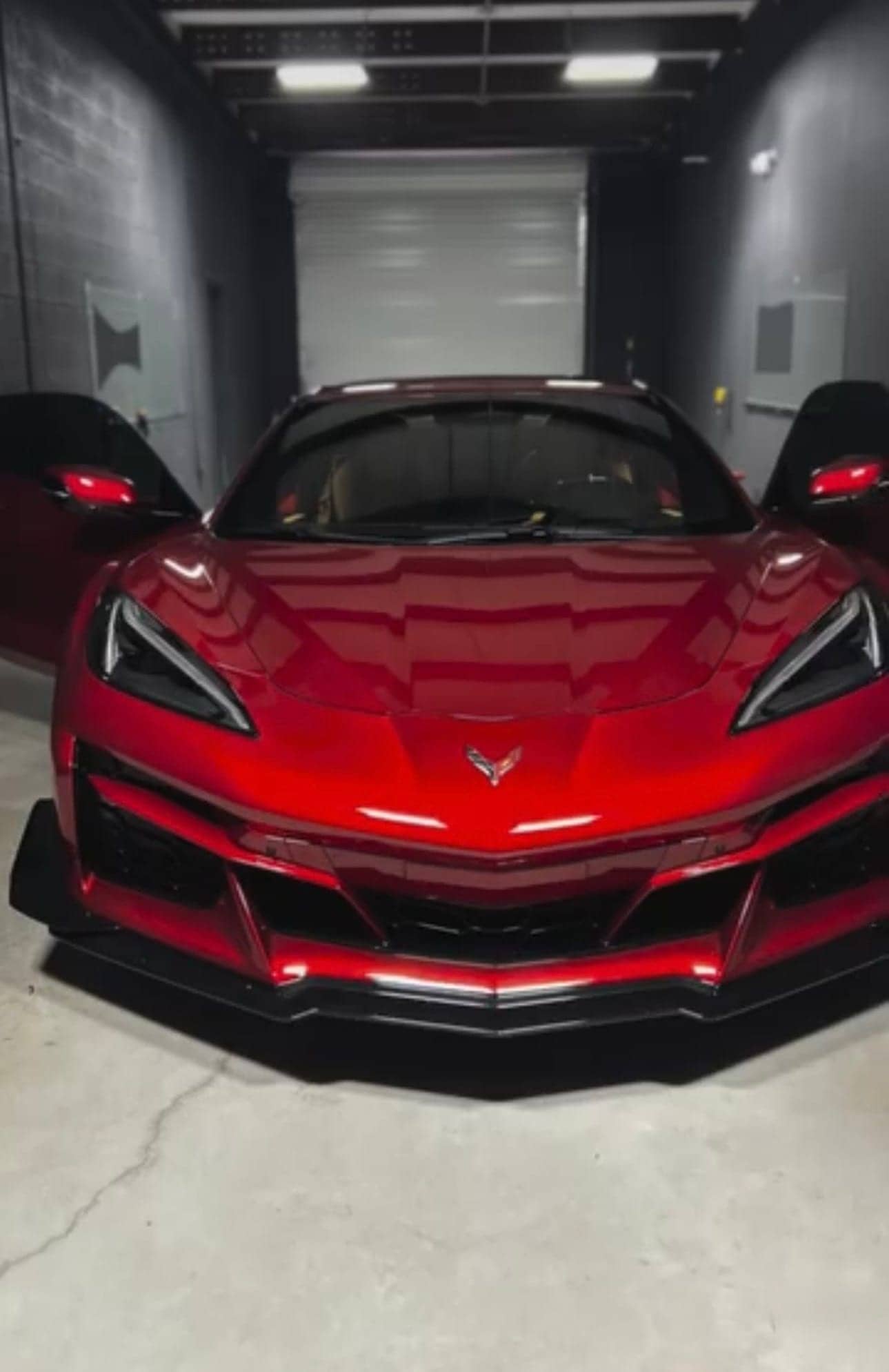 Red mid-engine Chevrolet Corvette with both doors open in the Equinox Tinting install bay